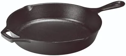 A perfectly seared steak with a golden crust on a dinner plate beside the skillet