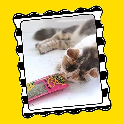 A cat rolling happily near a small pile of the catnip leaves on the floor