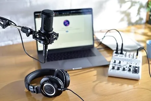 The AT2020 mounted on a boom arm with a pop filter in a home studio