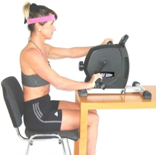 Pedaling the DeskCycle under a desk while working on a laptop