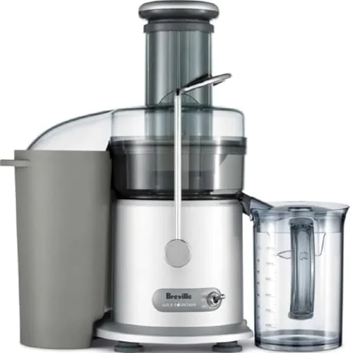 The Breville JE98XL Juice Fountain Plus on a kitchen counter with whole oranges and apples