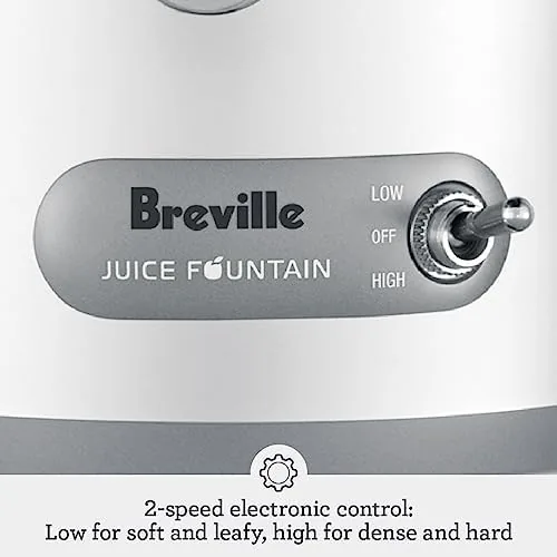 A whole apple being fed through the wide chute of the Breville juicer