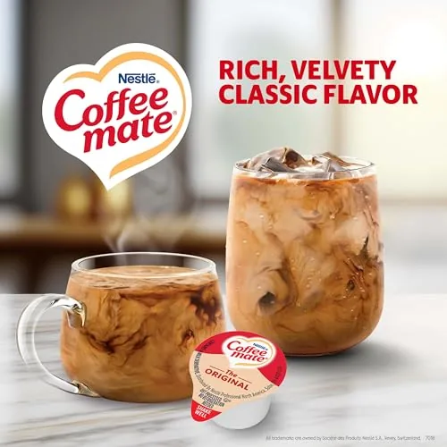 A single creamer packet being poured into a cup of black coffee