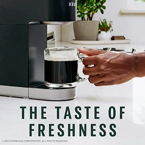 A cup of hot French Roast coffee being poured from a Keurig brewer