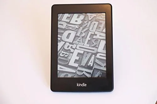 The Kindle Paperwhite resting on a soft surface with a book page in view