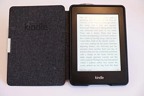 The Kindle open beside a leather cover on a bedside table
