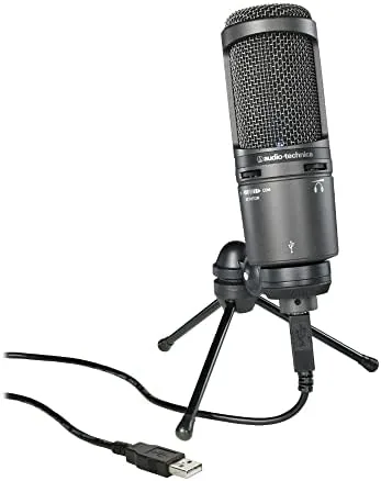 The Audio-Technica AT2020USB+ microphone on its tripod stand beside a computer