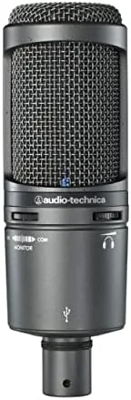 The microphone recording a podcast with a laptop and headphones in the scene