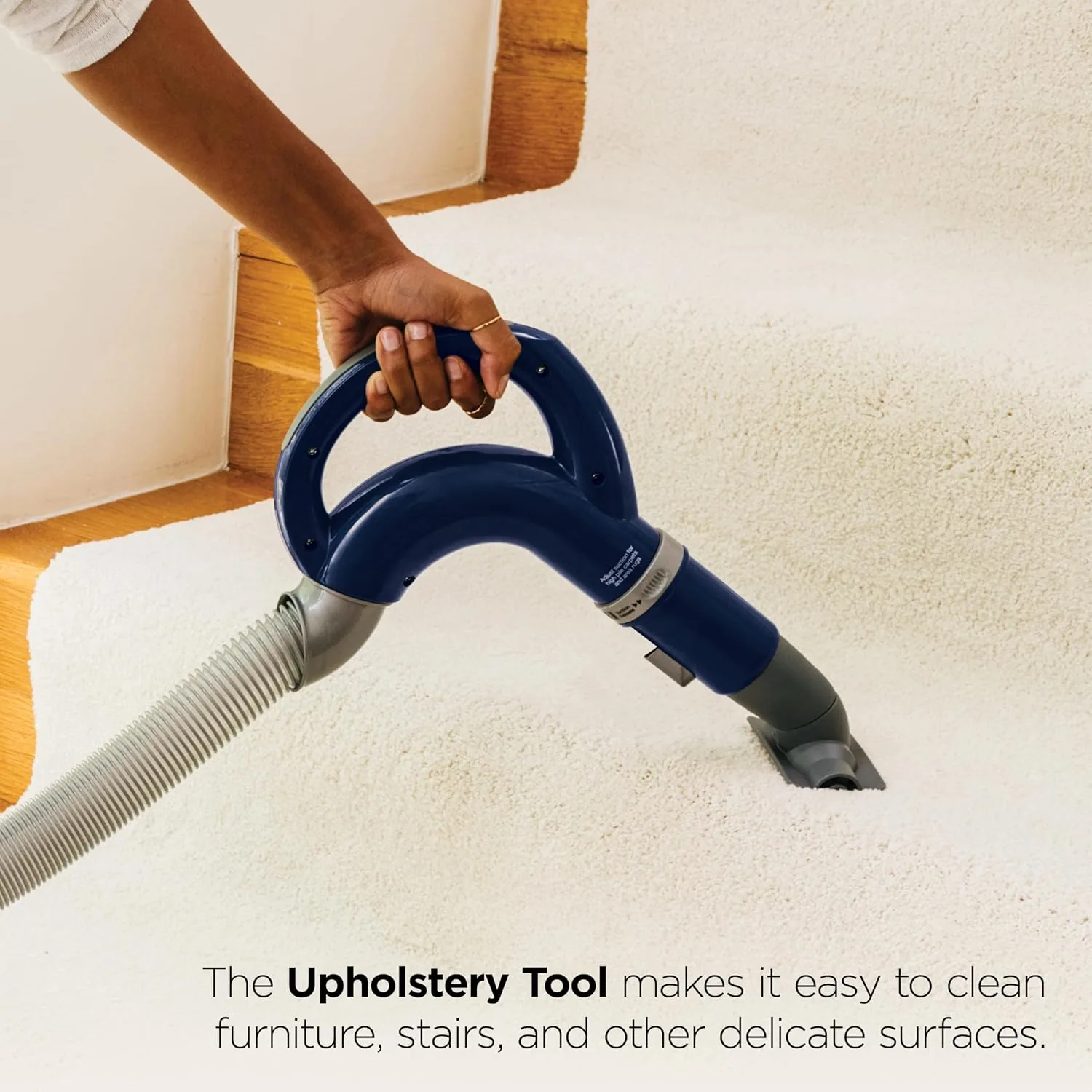 The NV360 picking up pet hair from a carpet with visible debris in the dust cup