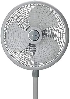 The Lasko 2526 lowered to its minimum height beside a bed