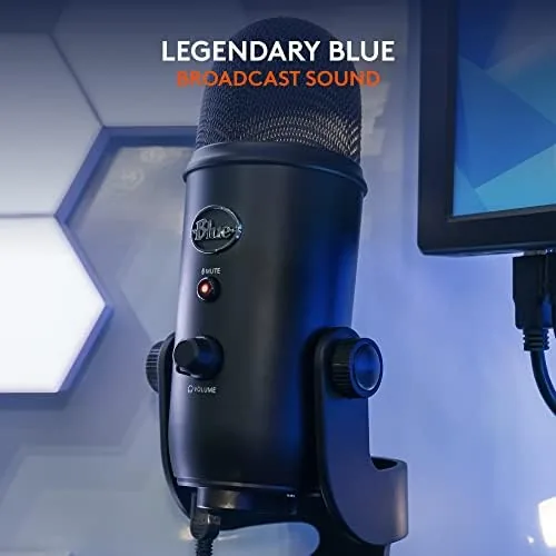 A streamer talking into the Blue Yeti with a game visible on the monitor behind