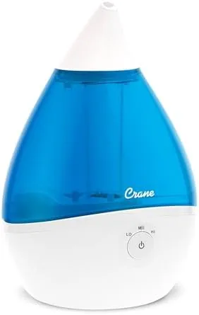 The Crane Droplet ultrasonic humidifier on a nightstand emitting cool mist