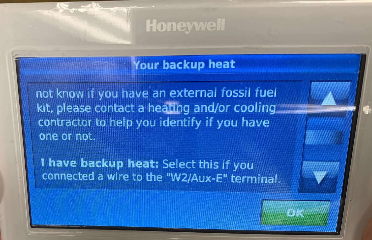 The Honeywell thermostat beside a basic manual thermostat for comparison
