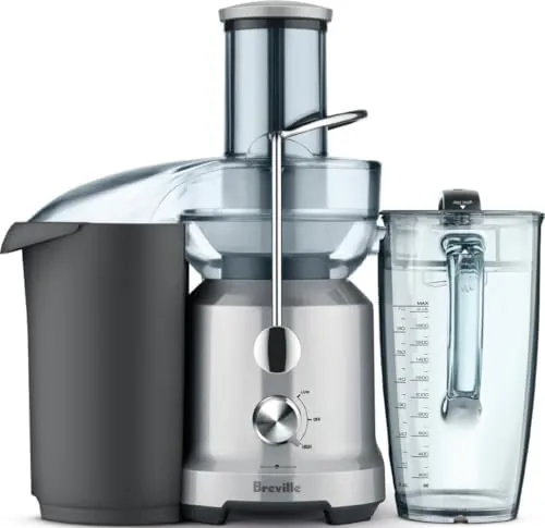 The Breville Juice Fountain Cold on a kitchen counter with fruit beside it