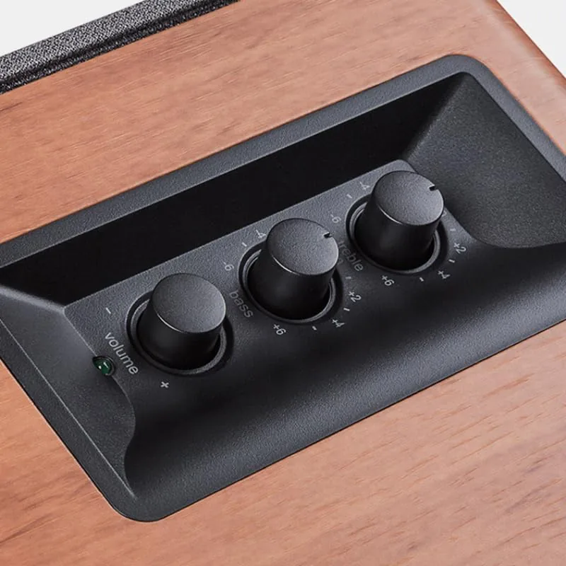 The volume, bass, and treble controls on the front of the right speaker