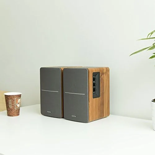 The R1280T speakers on a bookshelf in a small office setting