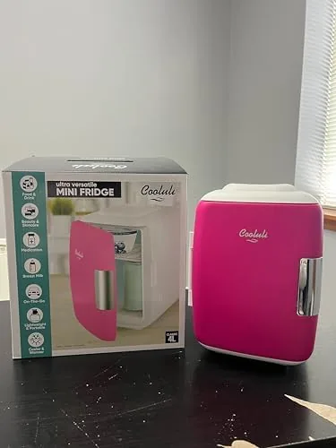 The fuchsia Cooluli fridge packed in a car with the DC cable visible