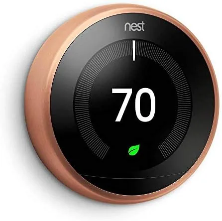 Copper Google Nest Learning thermostat mounted on a painted wall