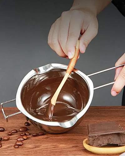 A candle being poured from the double boiler into a glass jar