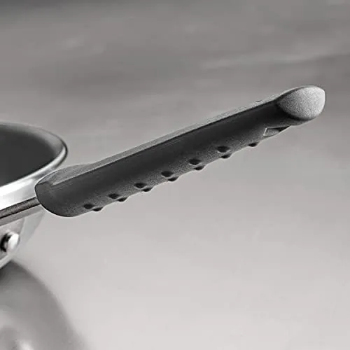 The Tramontina pan cooking vegetables on a modern stovetop