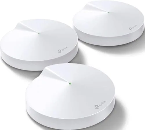 Three TP-Link Deco M5 mesh units on a shelf in a living room
