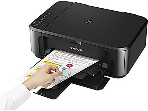 Printed documents and glossy photos laid out beside the MG3620