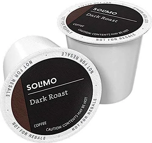 A 100 count box of Solimo dark roast coffee pods on a counter next to a Keurig brewer