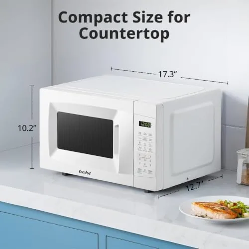 Compact microwave sitting on a dorm shelf next to a coffee maker