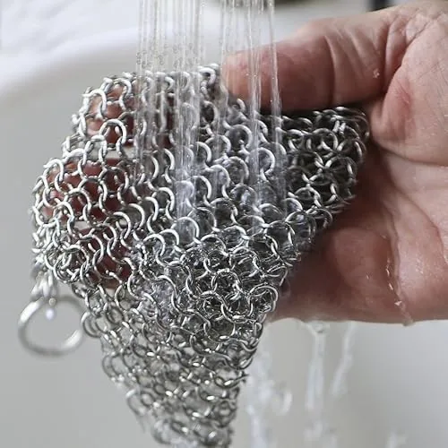 Chainmail scrubber hanging to dry over a kitchen sink