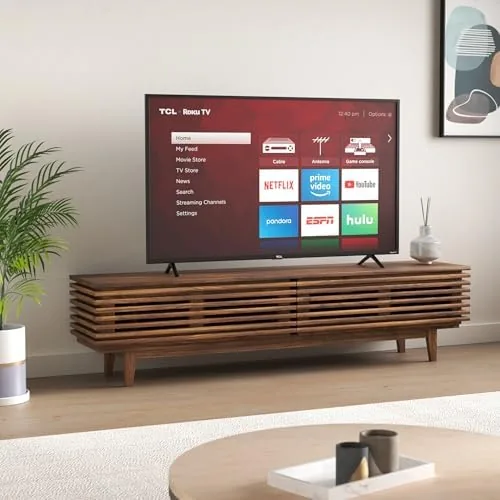Person using the Roku voice remote while watching the TCL 55S425