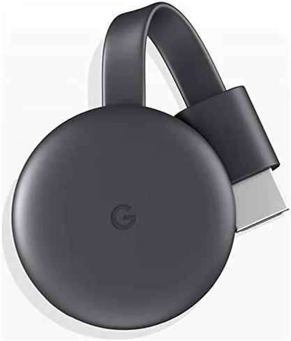 A hand holding the small round Chromecast dongle