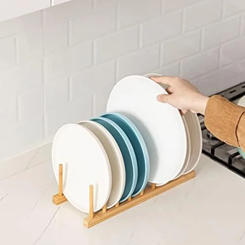 Pot lids and cutting boards standing in the vertical slots of the bamboo rack