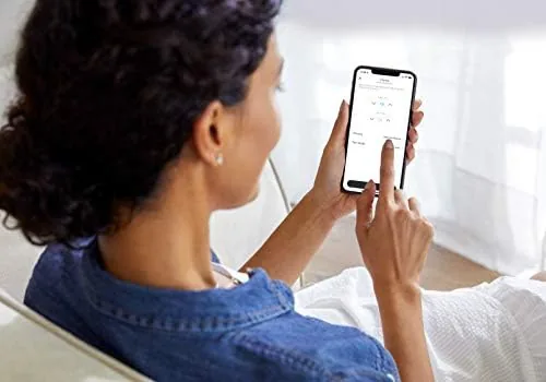 The white Smart Room Sensor puck sitting on a bedside table
