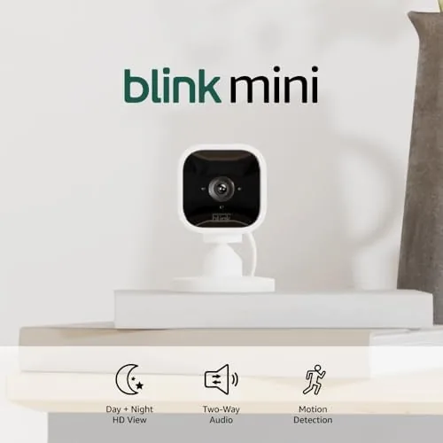 The Blink Mini white camera mounted on a wall pointing down a hallway