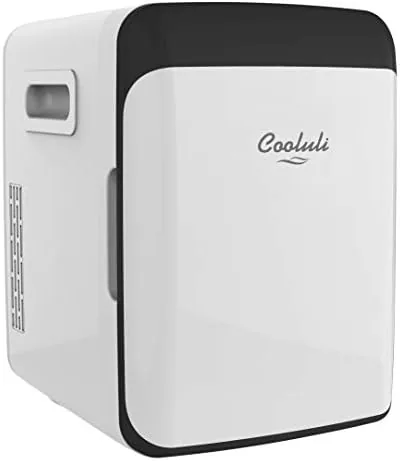 The white Cooluli 10L mini fridge sitting on a bedroom nightstand