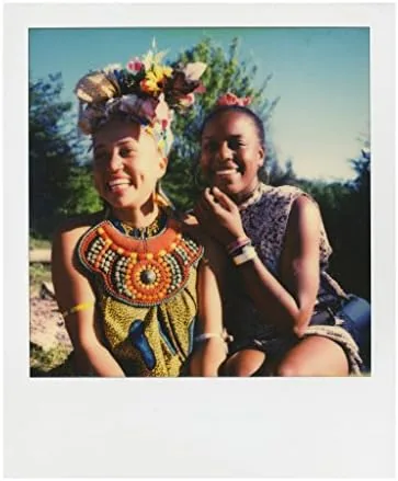 A freshly ejected photo developing from the front of a Polaroid camera