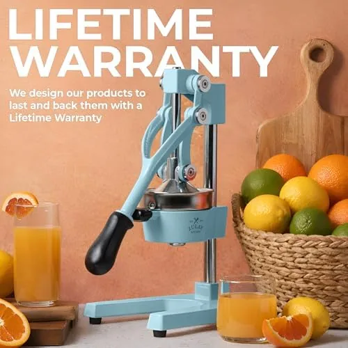 A full glass of fresh orange juice beside the Zulay cast iron juicer