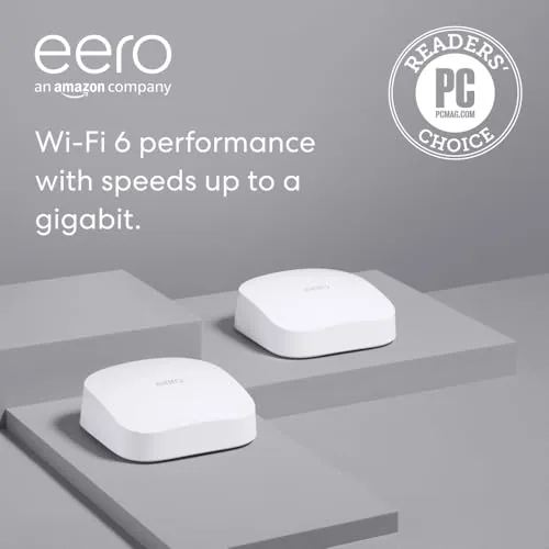 Two eero Pro 6 nodes sitting on a wooden shelf in a living room