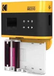 A stack of finished 2x3 prints from the KODAK 4PASS cartridge showing natural colors