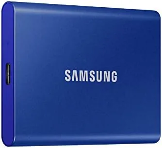 The blue Samsung T7 1TB SSD resting on a wooden desk beside a journal