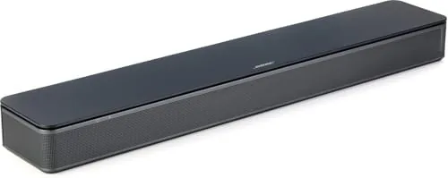 Bose TV Speaker soundbar on a media stand under a TV