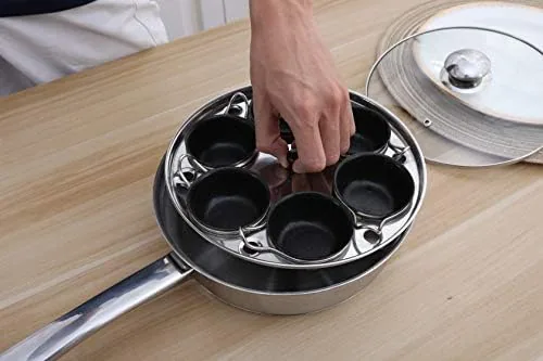 Four eggs poaching in the cups under the domed lid