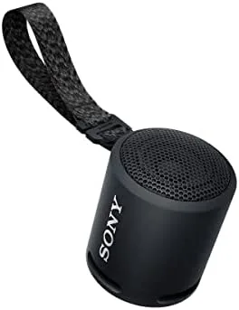 Sony compact waterproof Bluetooth speaker held in a hand on a kitchen counter