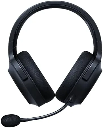 Razer Barracuda X wireless headset resting on a desk next to the USB-C dongle