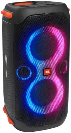 JBL PartyBox 110 standing upright in a backyard with lights off