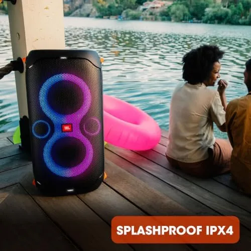 Testing setup showing the PartyBox app controls on a phone beside the speaker
