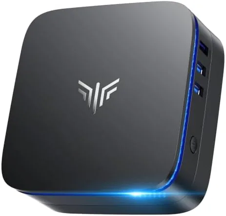 KAMRUI AK1PLUS mini PC on a desk beside a dual monitor setup