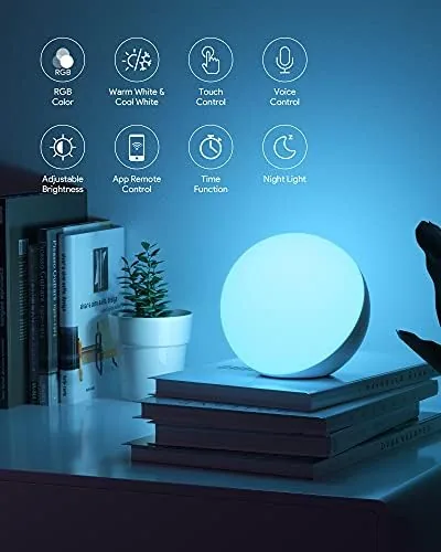 The smart lamp in warm color scene mode beside a phone showing the app