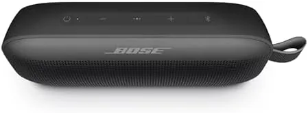 Bose SoundLink Flex hanging by its strap from a bag on a bench