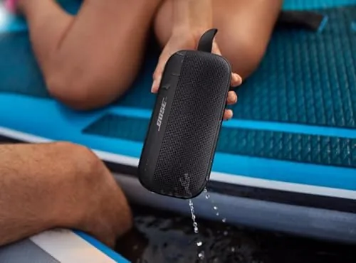 SoundLink Flex speaker drying beside a towel, bag, and cable